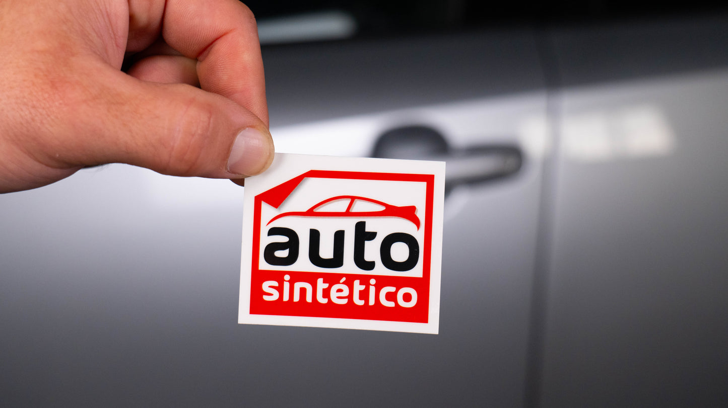 Etiqueta publicitaria a todo color Autosintetico, mostrada por una mano, perfecta para promover talleres mecánicos y recordar servicios de mantenimiento